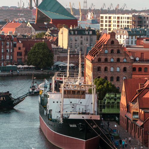 The ship "Sołdek", the Royal Granary, in the background the modern building of the Museum of the Second World War.